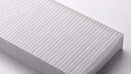 Zoomed in studio shot of an exposed cabin air filter. // Zoom en studio sur un filtre à air d'habitacle exposé