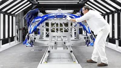 An engineer inspecting the body frame of a vehicle // Un ingénieur inspectant le châssis d'un véhicule