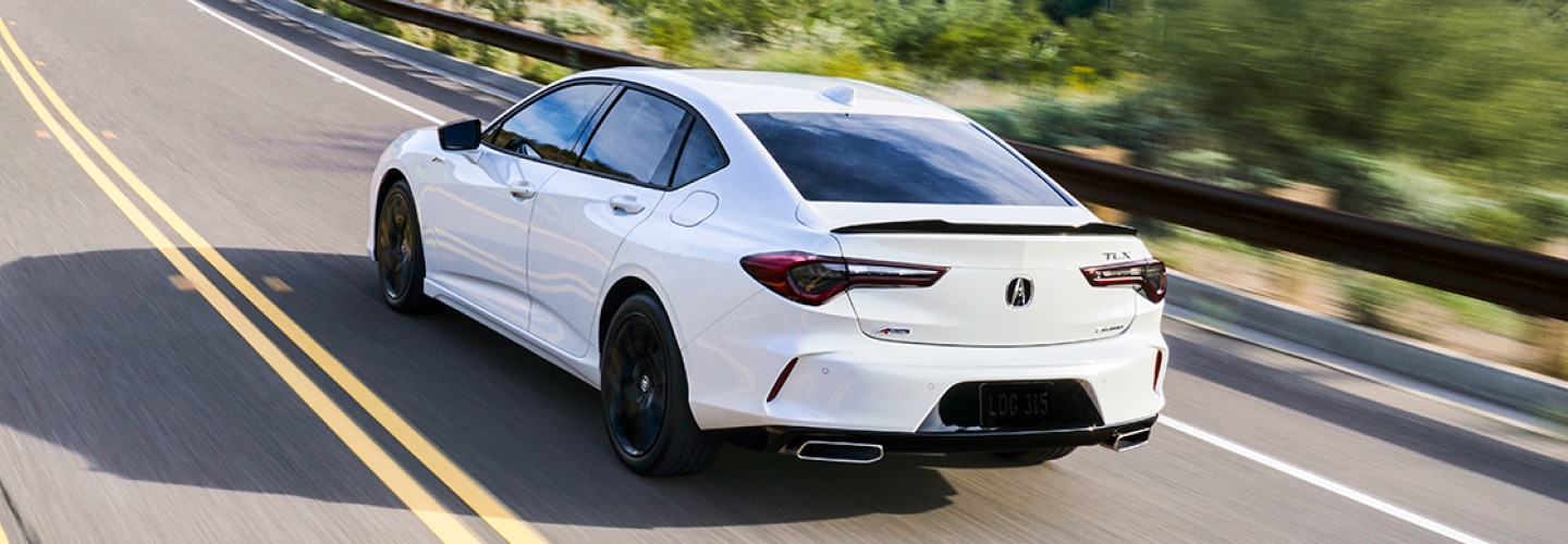 A white Acura TLX cruising around on the highway at a high speed. / Une Acura TLX blanche roulant sur l'autoroute à grande vitesse