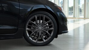 Tire profile shot of the front right rim and tire of an Acura ILX parked in a vehicle showroom. // Plan de profil de la jante avant droite et du pneu d'une Acura ILX stationnée dans une salle d'exposition de véhicules