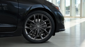 Tire profile shot of the front right rim and tire of an Acura ILX parked in a vehicle showroom. // Plan de profil de la jante avant droite et du pneu d'une Acura ILX stationnée dans une salle d'exposition de véhicules