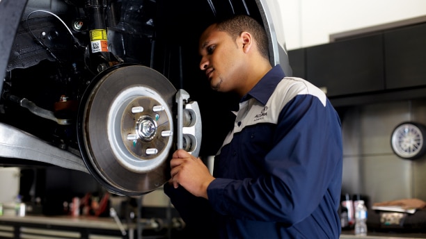 A certified Acura technician is inspecting the rotors and brake pads of an Acura vehicle.// Un technicien Acura certifié inspecte les disques et les plaquettes de frein d'un véhicule Acura.
