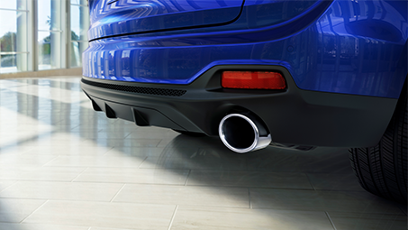 Close-up view of the back of a blue Acura showing rear bumper and tailpipe. // Vue rapprochée de l'arrière d’une Acura bleue montrant le pare-chocs arrière et le tuyau d'échappement.